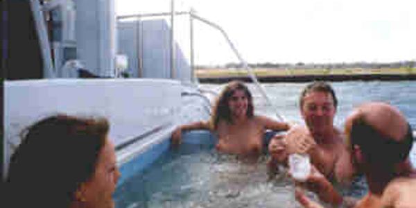 Guests relaxing in hot tub on yacht deck